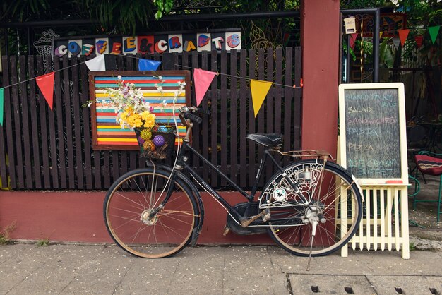 Foto chiang mai, thailand - 10. juni 2016: parken des alten fahrrads in der nähe des cafés in der stadt chiang mai.