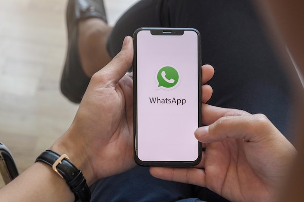 Foto chiang mai thailand 23 de enero de 2021 joven con teléfono inteligente en sus manos whatsapp en la pantalla iphone xs plus fue creado y desarrollado por la apple inc