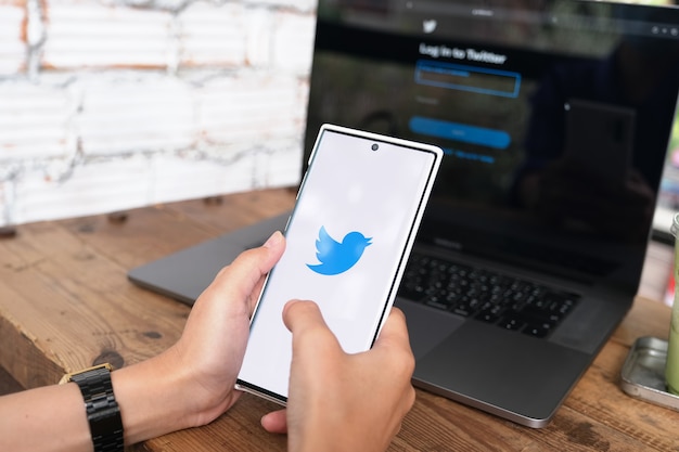 CHIANGMAI, TAILÂNDIA - 6 DE JUNHO DE 2021: Mulher segurando smartphone mobile com logotipo do Twitter na tela. O Twitter é um serviço online de mídia social para microblogging e comunicação em rede.