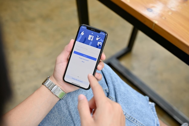 Chiangmai Tailandia 25 de agosto de 2022 Una mujer que usa su teléfono inteligente para iniciar sesión en su Facebook