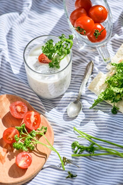 Chiasamen und Joghurt in einem Glas mit Gemüse und Tomaten