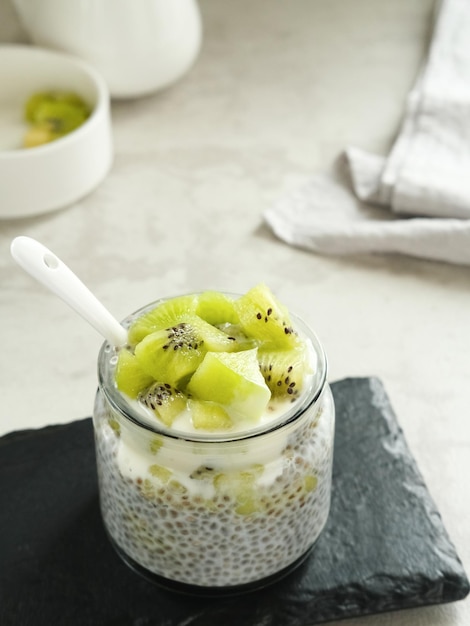 Chiaseed servido em um frasco de vidro coberto com iogurte e kiwi Muito fresco e saudável