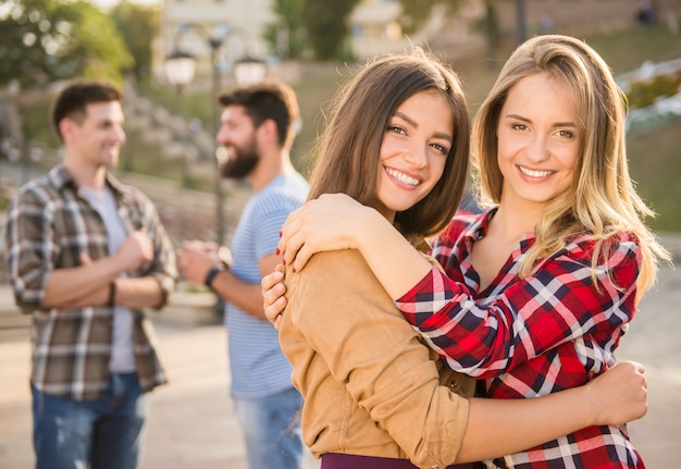 Chica abrazando a otra chica en la calle.