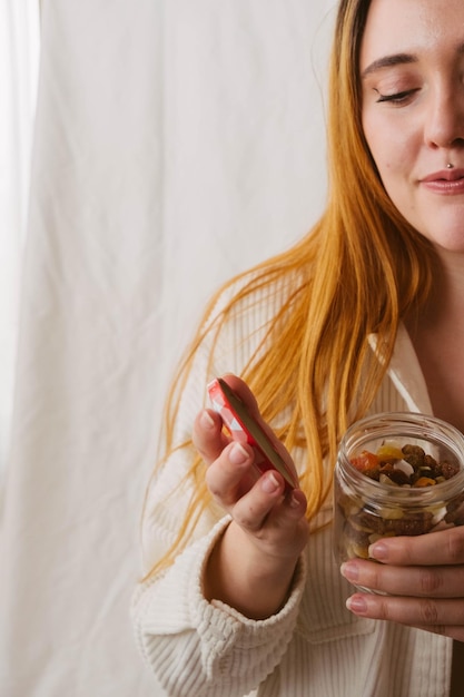 Chica abriendo un tarro de frutos secos