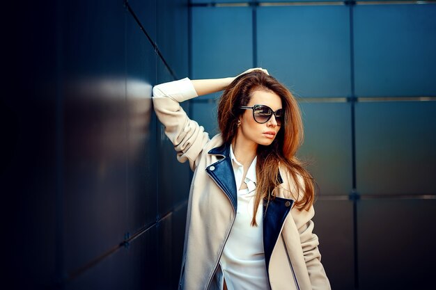 Chica en un abrigo beige y jeans azules