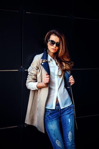 Chica en un abrigo beige y jeans azules