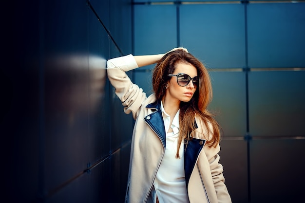 Chica en un abrigo beige y jeans azules