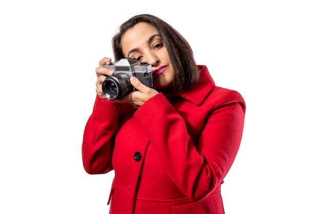 Chica con abrigo rojo usando una cámara antigua Fotografía conceptual Estilo vintage