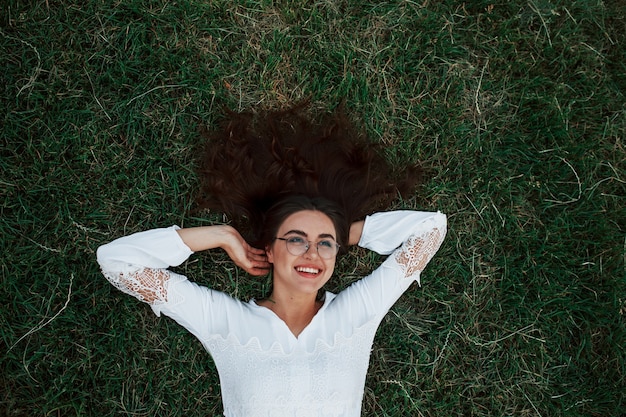 Chica acostada sobre la hierba verde y descansar