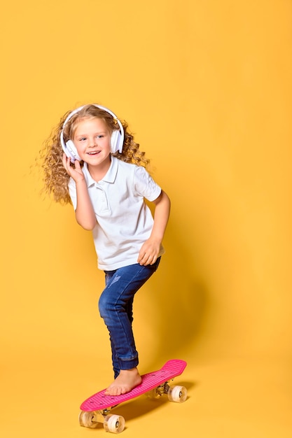 Chica activa y feliz con auriculares de pelo rizado divirtiéndose