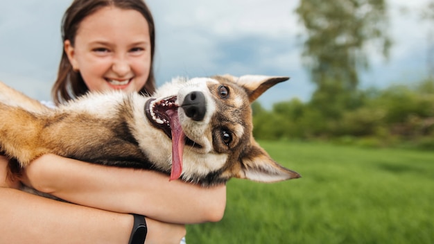 Foto chica adolescente abraza a un perro y miran a la cámara