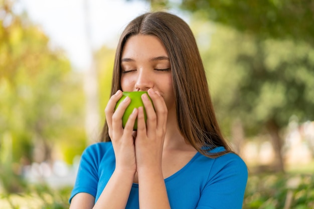 Chica adolescente al aire libre sosteniendo una manzana