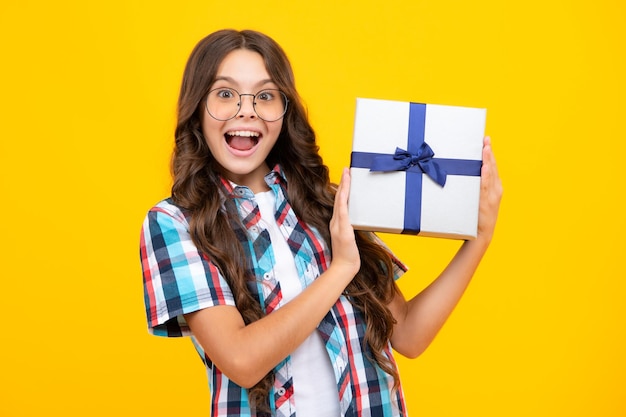 Chica adolescente asombrada Niño con caja de regalo presente sobre fondo aislado Regalos para cumpleaños Día de San Valentín Año Nuevo o Navidad Emocionado expresión alegre y alegre