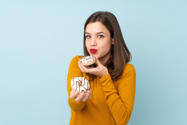 Foto chica adolescente en azul sosteniendo una rosquilla