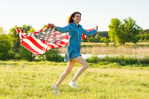 Chica adolescente con bandera americana corriendo