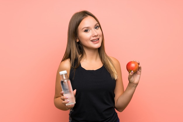 Chica adolescente con una botella de agua sobre aislado