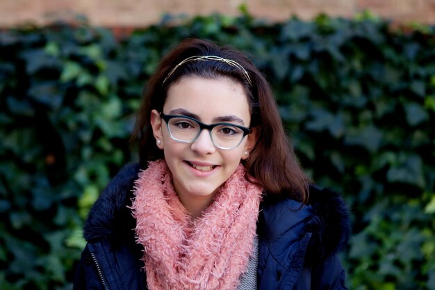 Chica adolescente con bufanda en el jardín