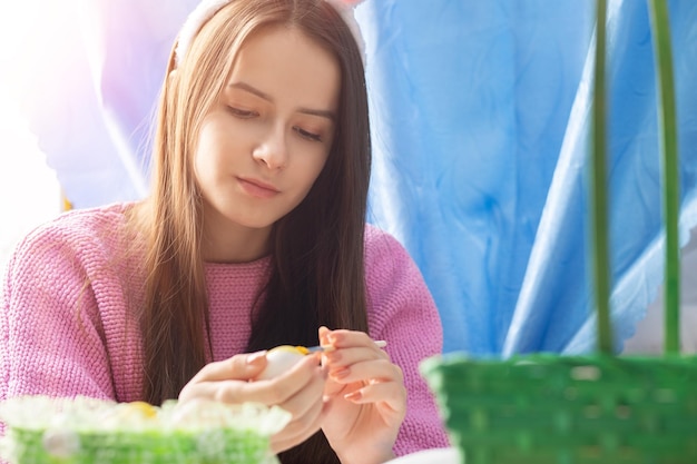 Chica adolescente decorar huevos para pascua de primavera