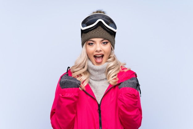 Chica adolescente esquiador con gafas de snowboard celebrando una victoria