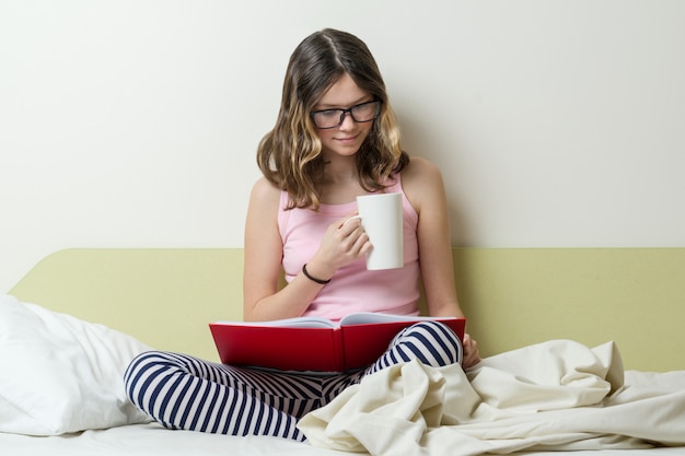 Chica adolescente estudiante de secundaria leyendo un libro de texto