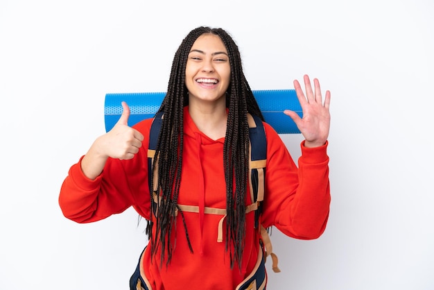 Chica adolescente excursionista con trenzas sobre fondo blanco aislado contando seis con los dedos