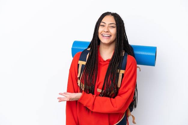 Chica adolescente excursionista con trenzas sobre fondo blanco aislado presentando una idea mientras mira sonriendo hacia