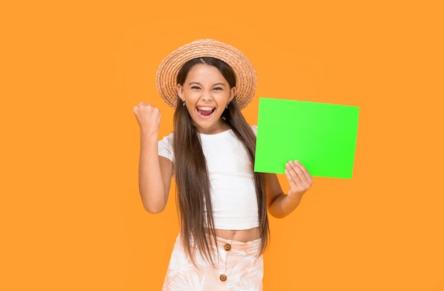 Chica adolescente exitosa con espacio de copia en papel verde sobre fondo amarillo