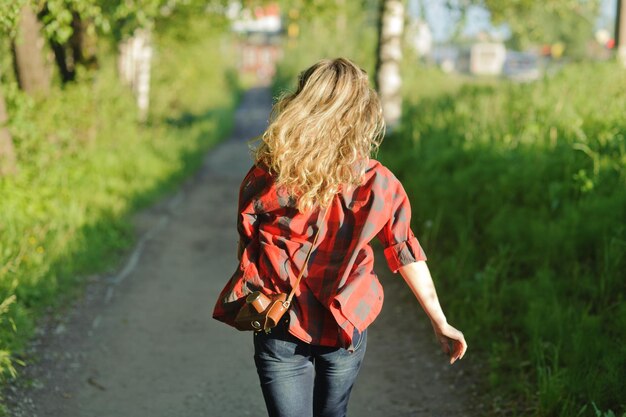 Foto chica adolescente feliz en camisa roja caminando