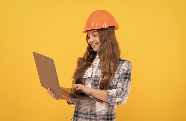 Foto chica adolescente feliz en casco y camisa a cuadros con educación portátil