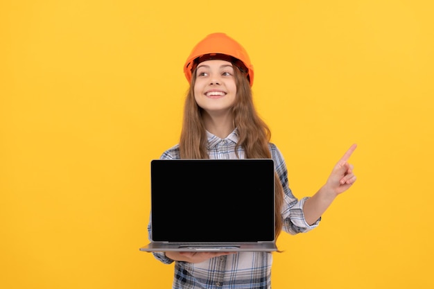 Chica adolescente feliz en casco y camisa a cuadros que presenta la promoción del dedo acusador portátil