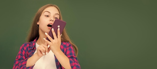 Chica adolescente feliz hablando por teléfono móvil en la escuela secundaria en el correo electrónico de voz de pizarra Banner de estudiante de escuela Retrato de alumno de colegiala con espacio de copia