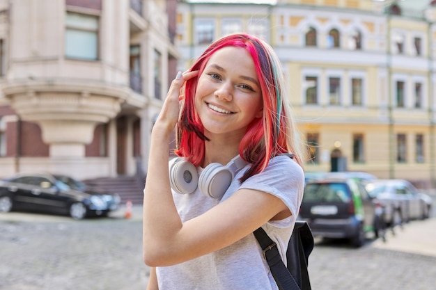 Chica adolescente feliz sonriente de moda con peinado de color teñido brillante en la ciudad