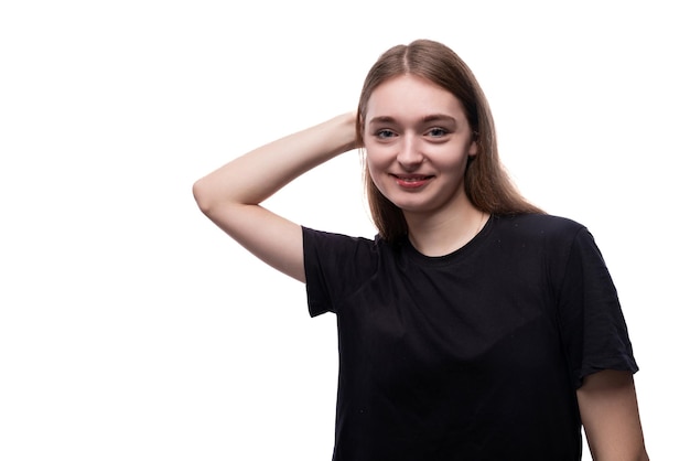 Chica adolescente guapa de cabello claro con una camiseta negra sobre un fondo blanco
