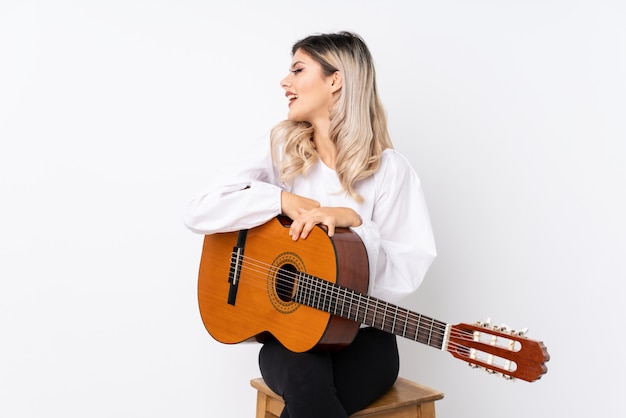 Chica adolescente con guitarra mirando de lado