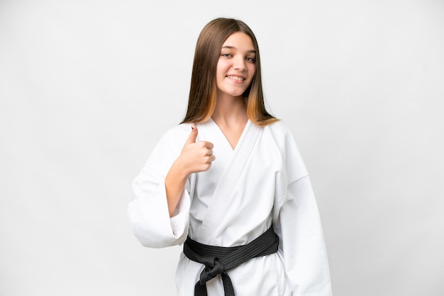 Chica adolescente haciendo karate sobre fondo blanco aislado dando un gesto de pulgares arriba