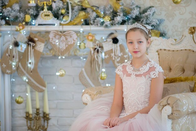 Chica adolescente hermosa en el árbol de Navidad