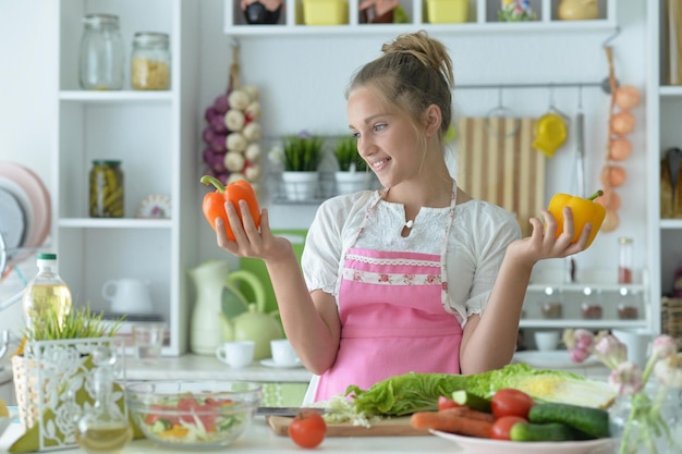 Chica adolescente hermosa cocinando en la cocina