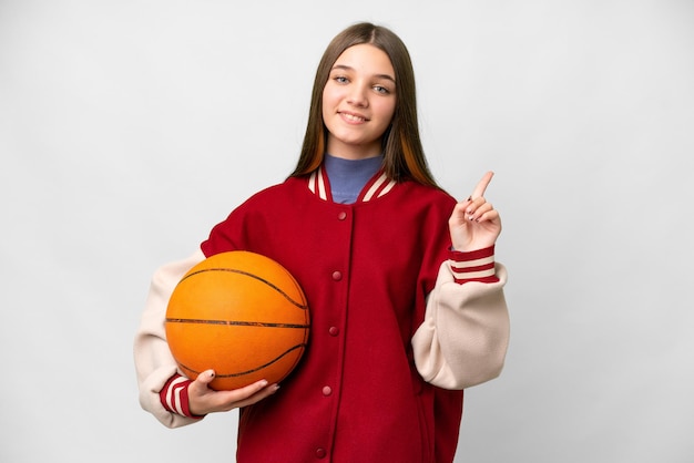 Chica adolescente jugando baloncesto sobre fondo blanco aislado mostrando y levantando un dedo en señal de lo mejor