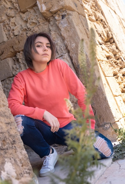 Chica adolescente con maqueta al aire libre de camisa de manga larga rosa