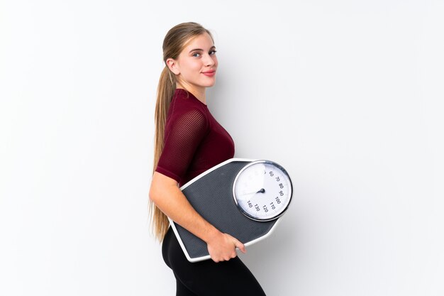 Chica adolescente con máquina de pesaje con máquina de pesaje