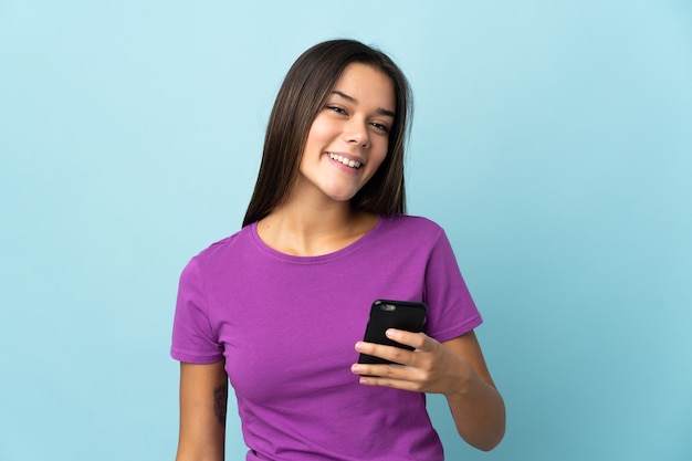 Foto chica adolescente en rosa mediante teléfono móvil