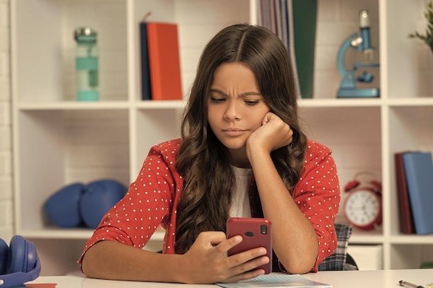 Chica adolescente seria ocupada usando la infancia del teléfono móvil