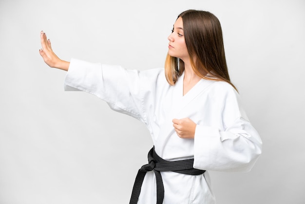 Chica adolescente sobre fondo blanco aislado haciendo karate