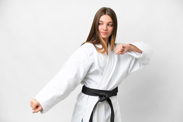 Chica adolescente sobre fondo blanco aislado haciendo karate