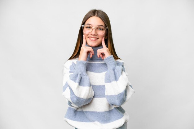 Chica adolescente sobre fondo blanco aislado sonriendo con una expresión feliz y agradable