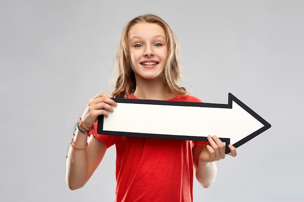 chica adolescente sonriente con una flecha que muestra la dirección