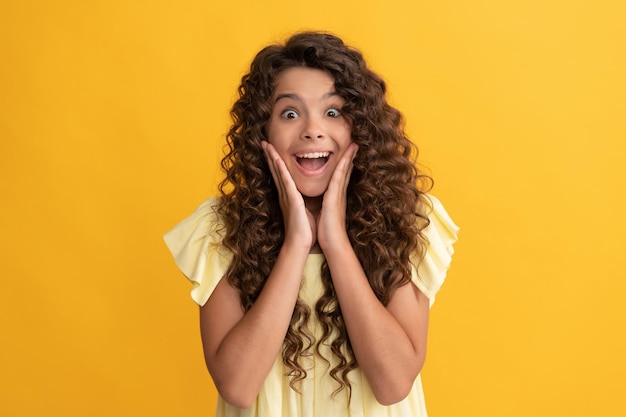 Chica adolescente sorprendida con cabello largo y rizado y cabello de piel perfecto