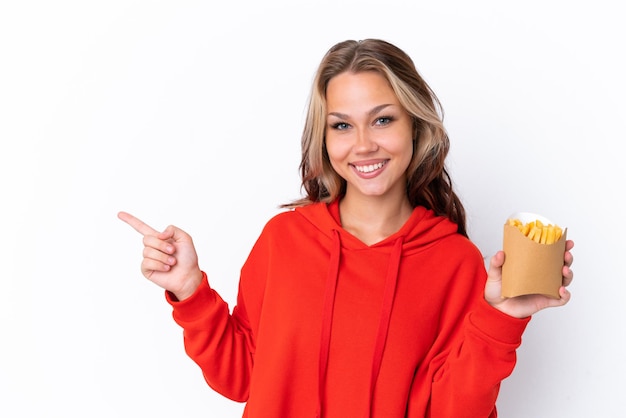 Chica adolescente sorprendida con muchas verduras sobre pared verde