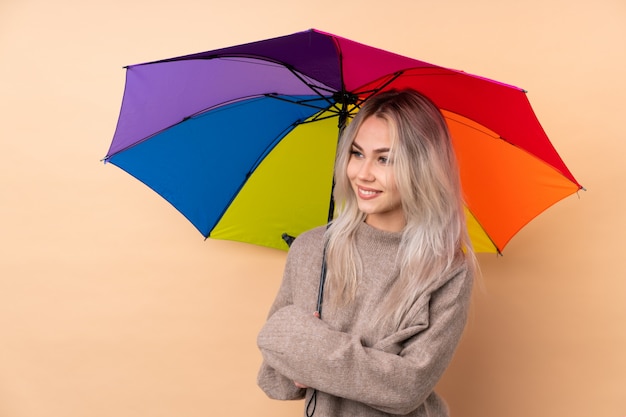 Chica adolescente sosteniendo un paraguas mirando hacia el lado