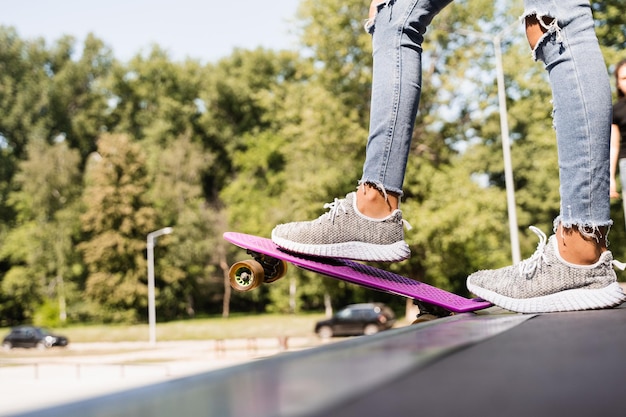 Chica adolescente con tablero de centavo listo para bajar en el parque de patinetas Equipo deportivo Estilo de vida extremo